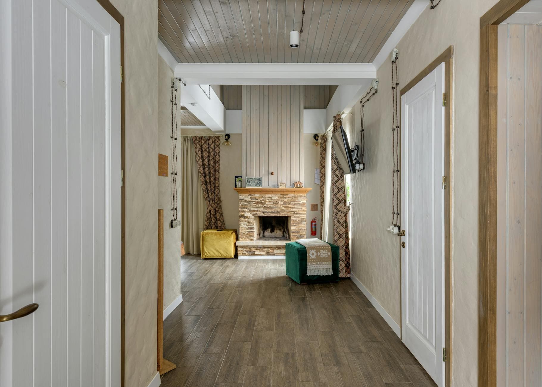 Entrée d'un chalet de montagne, cheminée en pierre et parquet
