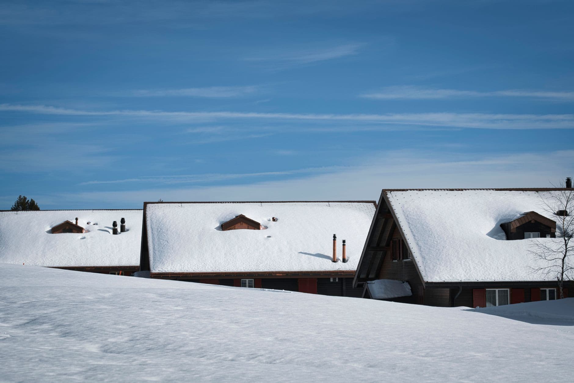 Toits de chalets couverts de neige sous un ciel bleu