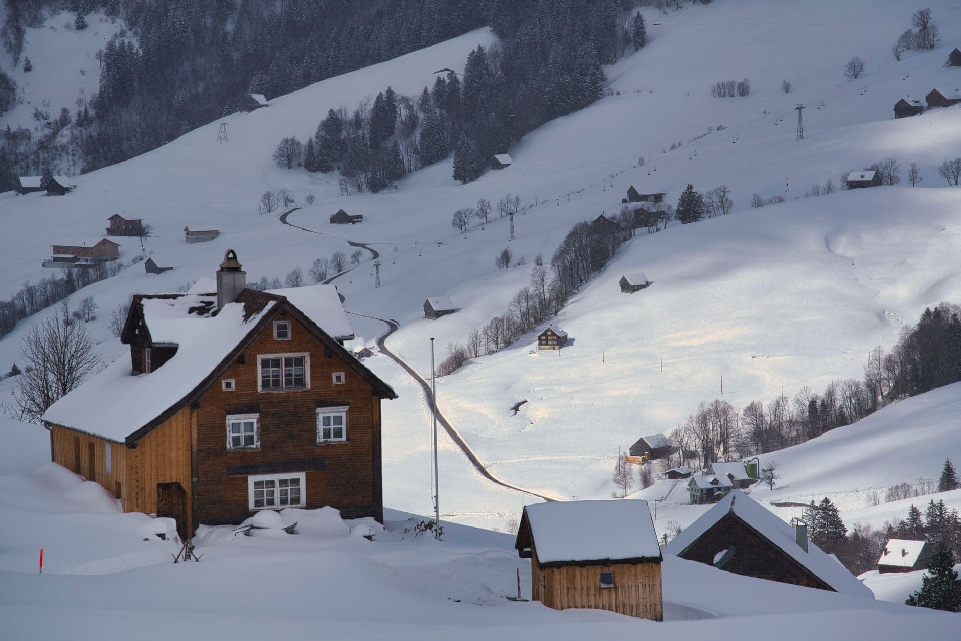 Village alpin enneigé et son télésiège en fin de journée