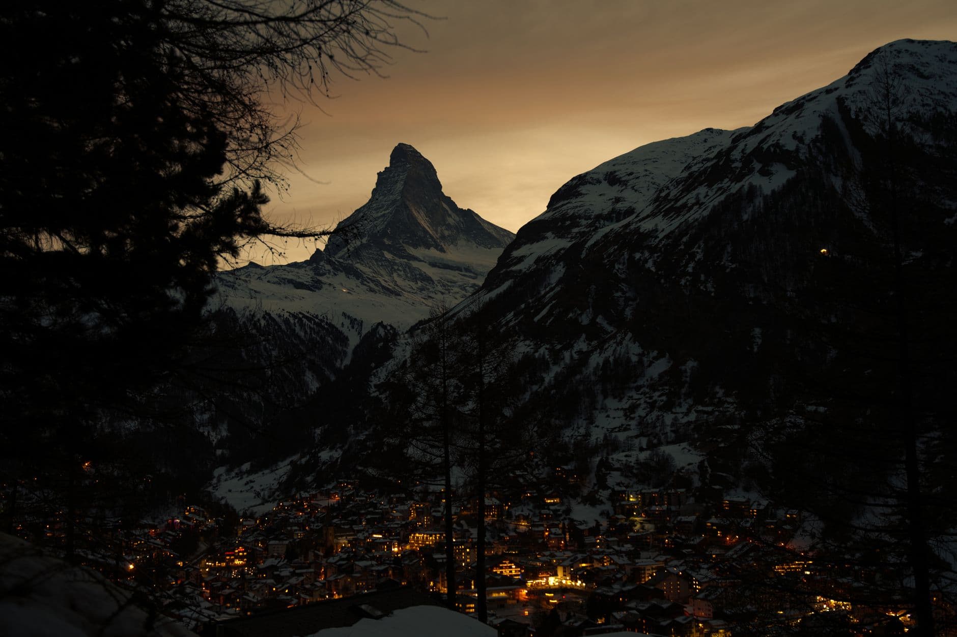Village de montagne à la tombée du jour, fenêtres éclairées